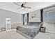 Comfortable bedroom featuring neutral tones, ceiling fan and ample natural light from the many windows with decorative curtains at 12704 Vander Way, New Port Richey, FL 34654