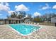 Outdoor community pool with a spacious deck and nearby clubhouse at 12704 Vander Way, New Port Richey, FL 34654