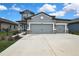 Two-story home featuring a three-car garage, concrete driveway, and manicured landscaping at 12704 Vander Way, New Port Richey, FL 34654