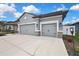 Exterior view of the home showcasing a three-car garage and well-manicured landscaping at 12704 Vander Way, New Port Richey, FL 34654