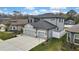 Aerial view of a home with a well-manicured lawn and a long driveway leading to a three car garage at 12704 Vander Way, New Port Richey, FL 34654