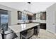 Modern kitchen with stainless steel appliances, a large central island with seating, and dark cabinetry at 12704 Vander Way, New Port Richey, FL 34654