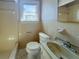 Cozy bathroom with a toilet, sink, shower and window with outside view at 13331 1St E St, Madeira Beach, FL 33708