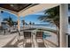 Covered balcony with seating overlooking the ocean, palm trees, and a private jacuzzi tub at 15912 Gulf Blvd, Redington Beach, FL 33708