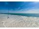 Calm ocean view with white sand, gentle waves, and a fishing rod at 15912 Gulf Blvd, Redington Beach, FL 33708