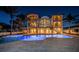 Night shot of a luxurious home with a pool and illuminated balconies at 15912 Gulf Blvd, Redington Beach, FL 33708