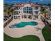 Aerial view of a large waterfront home with a pool, lush lawn, and beautiful patio area at 15912 Gulf Blvd, Redington Beach, FL 33708