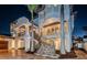 Beautiful multi-story home with ornate iron railings, exterior staircase, and lush landscaping against a twilight sky at 15912 Gulf Blvd, Redington Beach, FL 33708