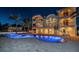 Luxurious home with a pool and illuminated balconies at night at 15912 Gulf Blvd, Redington Beach, FL 33708