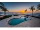 Beachside pool and spa area enhanced by palm trees and a vibrant sunset at 15912 Gulf Blvd, Redington Beach, FL 33708