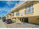 Charming two-story condo building with carports and wrought iron balconies, under a bright blue sky at 16333 Gulf Blvd # 105, St Petersburg, FL 33708