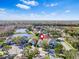 Aerial view of a neighborhood with a pond, houses, and trees, highlighting the community's setting at 1645 Fennsbury Ct, Wesley Chapel, FL 33544