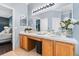 Bathroom featuring double sinks with wood cabinetry and an adjacent main bedroom view at 1645 Fennsbury Ct, Wesley Chapel, FL 33544