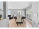 Elegant dining area with neutral walls, a modern table set, and an adjoining living area at 1645 Fennsbury Ct, Wesley Chapel, FL 33544