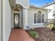 Inviting front entry with brick pathway and decorative glass front door at 1645 Fennsbury Ct, Wesley Chapel, FL 33544