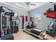 A bright home gym featuring exercise equipment, a window, and tan tile flooring at 1645 Fennsbury Ct, Wesley Chapel, FL 33544