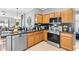 Well-lit kitchen featuring stainless steel appliances, granite countertops, and wood cabinets at 1645 Fennsbury Ct, Wesley Chapel, FL 33544