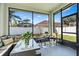 Enclosed patio with black mesh screen, patio furniture, potted plant, and view of the backyard at 1645 Fennsbury Ct, Wesley Chapel, FL 33544