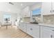 Bright kitchen with white shaker cabinets, herringbone backsplash, and quartz countertops at 167 83Rd N Ave, St Petersburg, FL 33702