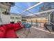 Screened-in pool area with red couch, table, and chairs, perfect for outdoor entertaining at 1672 Cambridge Dr, Clearwater, FL 33756