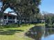 Exterior of condo building with lake view, mature trees, and green lawn at 2070 Lakeview Dr # 206, Clearwater, FL 33763