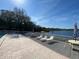 Community pool deck features lounge chairs and tables by the lake, ideal for relaxation and socializing at 2070 Lakeview Dr # 206, Clearwater, FL 33763