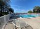 Community pool overlooking the lake, complete with brick paved deck, lounge chairs, and palm trees at 2070 Lakeview Dr # 206, Clearwater, FL 33763