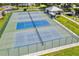 Aerial view of well-maintained tennis courts with blue and green surfaces, surrounded by fencing and greenery at 2226 Switzerland Way # 52, Clearwater, FL 33763