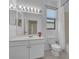 Bathroom with a white vanity, floral accent and an expansive mirror at 237 Shell Falls Dr, Apollo Beach, FL 33572