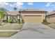 Exterior view of a single-story home featuring a two-car garage, tile roof, and manicured landscaping at 237 Shell Falls Dr, Apollo Beach, FL 33572