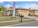 Curb view of single-story home with two car garage, mature landscaping, and tile roof at 237 Shell Falls Dr, Apollo Beach, FL 33572