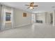 Living room with tile flooring, ceiling fan, and large windows with white curtains at 237 Shell Falls Dr, Apollo Beach, FL 33572