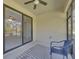 Covered patio area with tiled flooring, ceiling fan, and a comfortable blue chair at 237 Shell Falls Dr, Apollo Beach, FL 33572