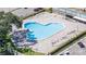 Aerial view of heart-shaped pool and lounge chairs, with parking lot and palm trees in the background at 2441 Persian Dr # 53, Clearwater, FL 33763