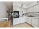 Well-lit kitchen featuring white cabinets, black oven, and hardwood flooring at 2441 Persian Dr # 53, Clearwater, FL 33763