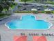 Large outdoor community swimming pool with lounge chairs, umbrellas, and a spacious deck area at 2441 Persian Dr # 53, Clearwater, FL 33763