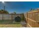 Backyard featuring a black grill covered, a wooden fence, and green grass with a blue sky above at 2749 16Th N Ave, St Petersburg, FL 33713