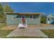 Charming home with a grass yard, featuring a red front door and white stairs leading up to the entrance at 2749 16Th N Ave, St Petersburg, FL 33713