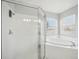 Bathroom showing a glass-enclosed shower, soaking tub, and natural light from the window at 2811 Butterfly Landing Dr, Land O Lakes, FL 34638