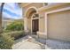 Welcoming front entrance with a covered porch, arched doorway, and meticulously maintained landscaping at 2811 Butterfly Landing Dr, Land O Lakes, FL 34638