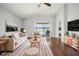 Light-filled living room with hardwood floors, providing access to a porch overlooking the serene lake at 2811 Butterfly Landing Dr, Land O Lakes, FL 34638