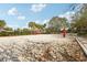 Outdoor sand volleyball court ready for a game with blue skies and lush landscaping in the background at 2811 Butterfly Landing Dr, Land O Lakes, FL 34638