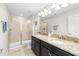 Bathroom featuring dual sinks with granite counters, walk-in shower and tile floors at 28635 Tranquil Lake Cir, Wesley Chapel, FL 33543