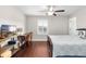 Bedroom showcasing wood floors, ceiling fan, window with blinds and a mounted TV at 28635 Tranquil Lake Cir, Wesley Chapel, FL 33543