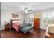 Bedroom with hard wood floors, ceiling fan, windows, and a settee at 28635 Tranquil Lake Cir, Wesley Chapel, FL 33543