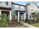 Two story home with blue exterior, covered entrance, stone accents, and a well-maintained front yard at 28635 Tranquil Lake Cir, Wesley Chapel, FL 33543