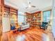 Home office featuring hardwood floors, custom built-in bookshelves, and a comfortable reading chair at 2902 N Shoreview Pl, Tampa, FL 33602