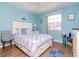 Comfortable blue bedroom with a queen-size bed and hardwood floors at 300 Glennes Ln # 208, Dunedin, FL 34698