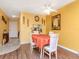 Dining area featuring wood floors, yellow walls, a ceiling fan, and seating for four around a table at 300 Glennes Ln # 208, Dunedin, FL 34698