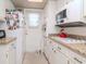 View of kitchen featuring white cabinets, granite countertops, and a window at 300 Glennes Ln # 208, Dunedin, FL 34698